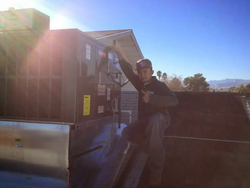 HVAC technician performing AC Tune-Up on a rooftop unit in Lakewood Ranch
