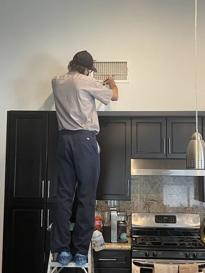 Technician inspecting an air vent during HVAC service in Lakewood Ranch